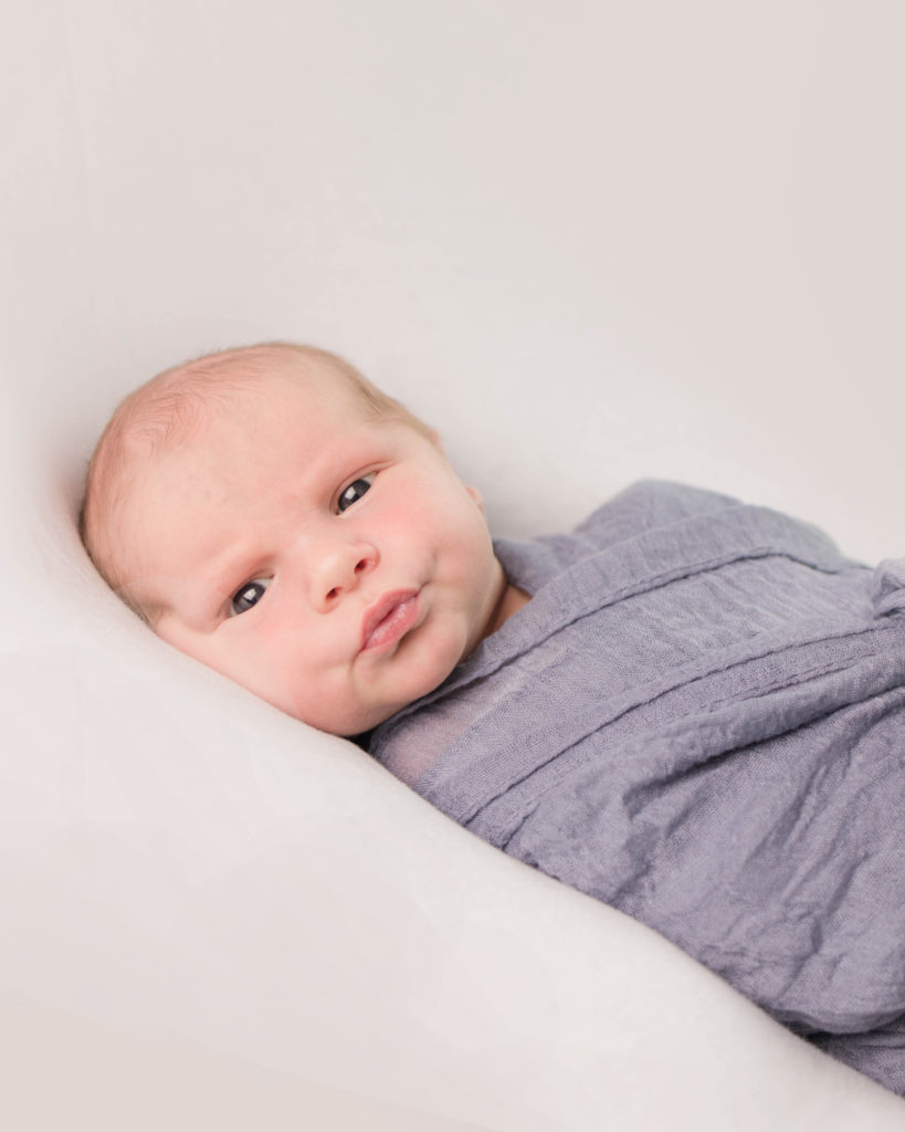 newborn baby boy on white backdrop by Cincinnati Hyde Park Photographer