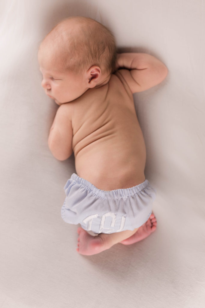 Newborn baby boy white backdrop with monogrammed diaper cover by Cincinnati Hyde Park Photographer